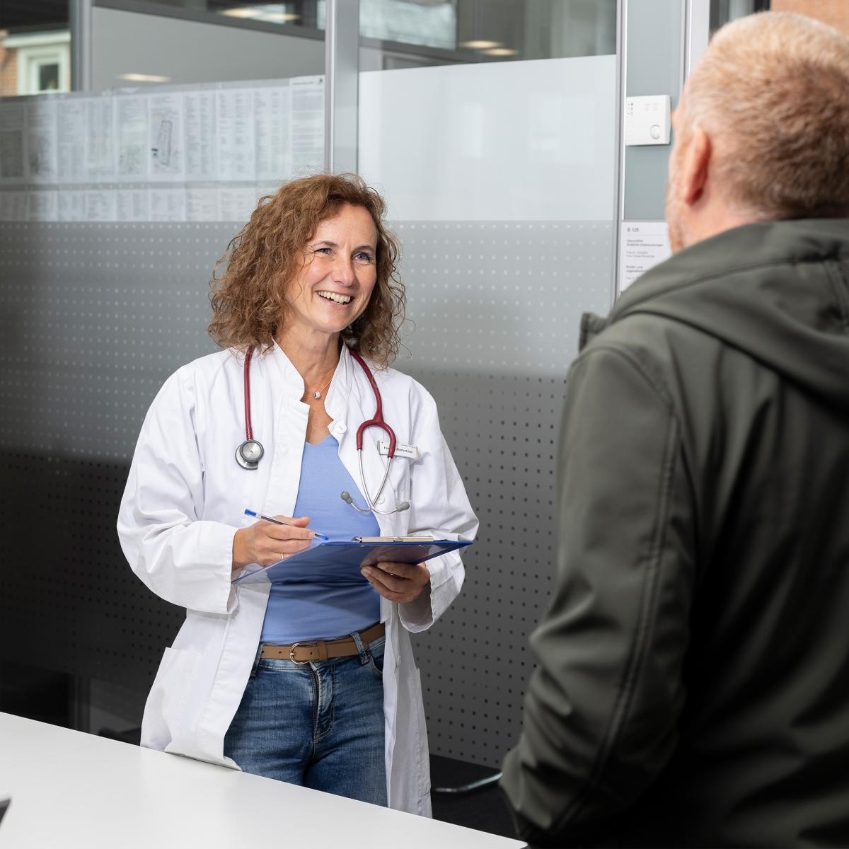 Ärztin steht vor einem Mann